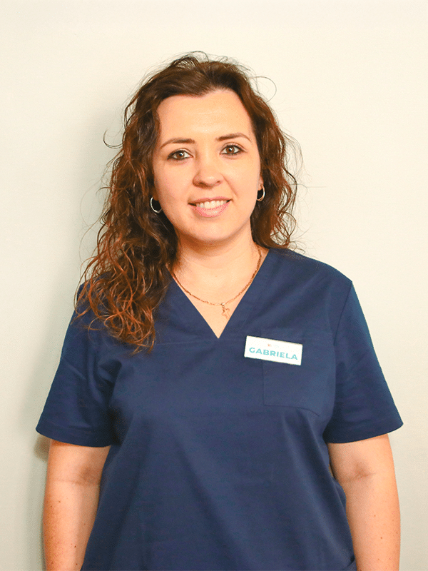 Donna con uniforme medica blu e cartellino.