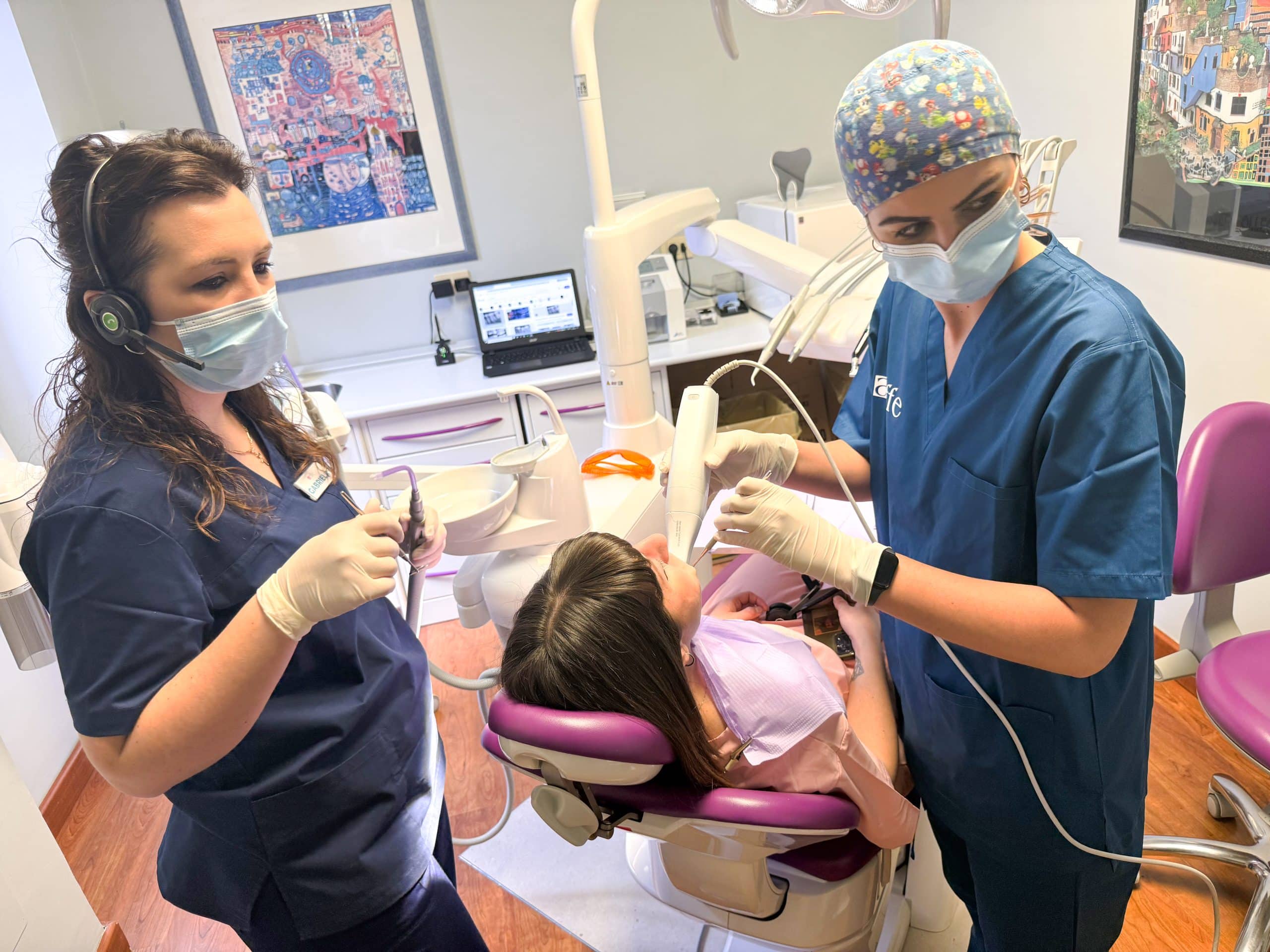 Dentista e assistente curano paziente in studio dentistico.