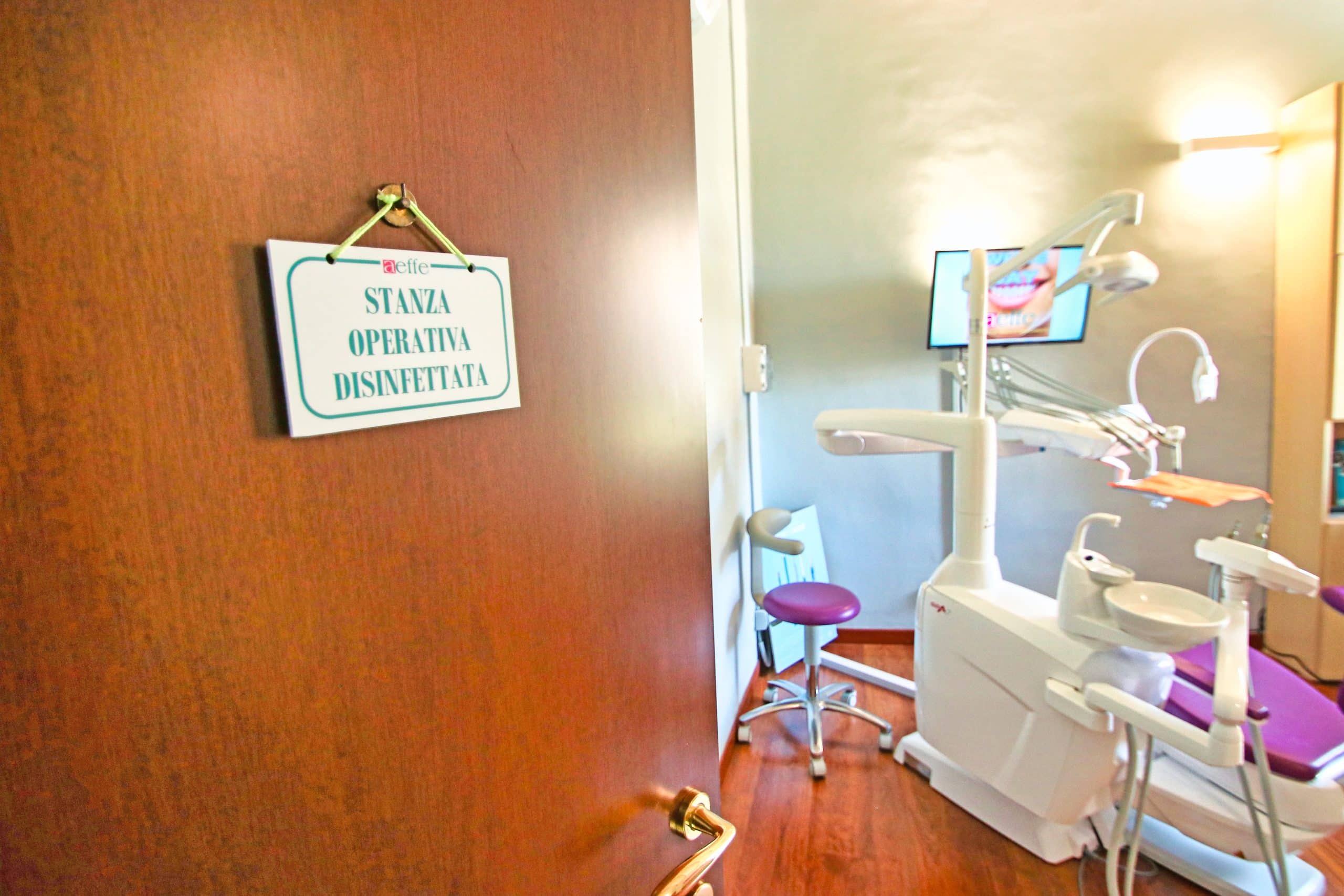 Porta aperta verso studio dentistico con attrezzature.