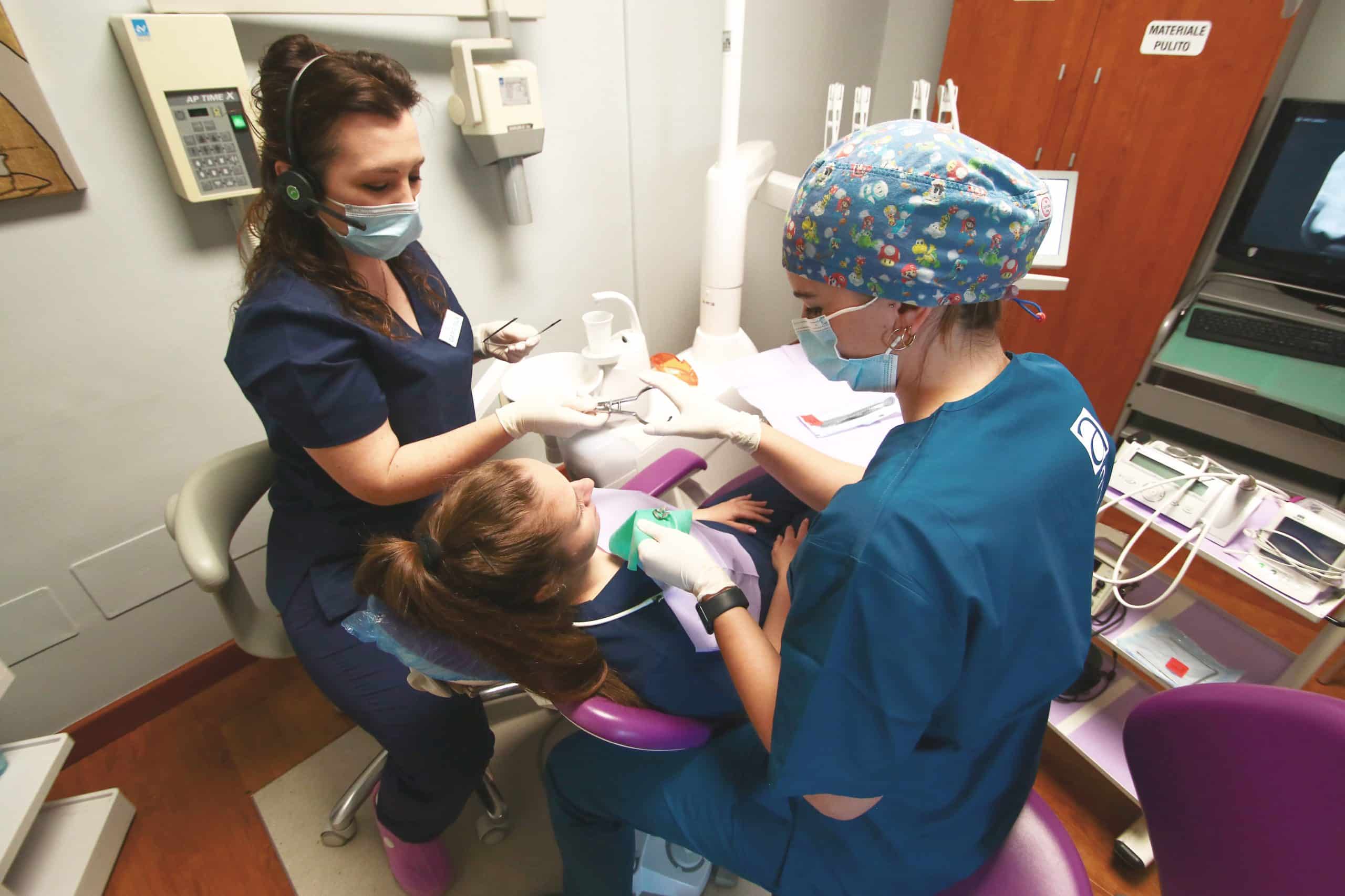 Dentiste curano una bambina in uno studio dentistico.