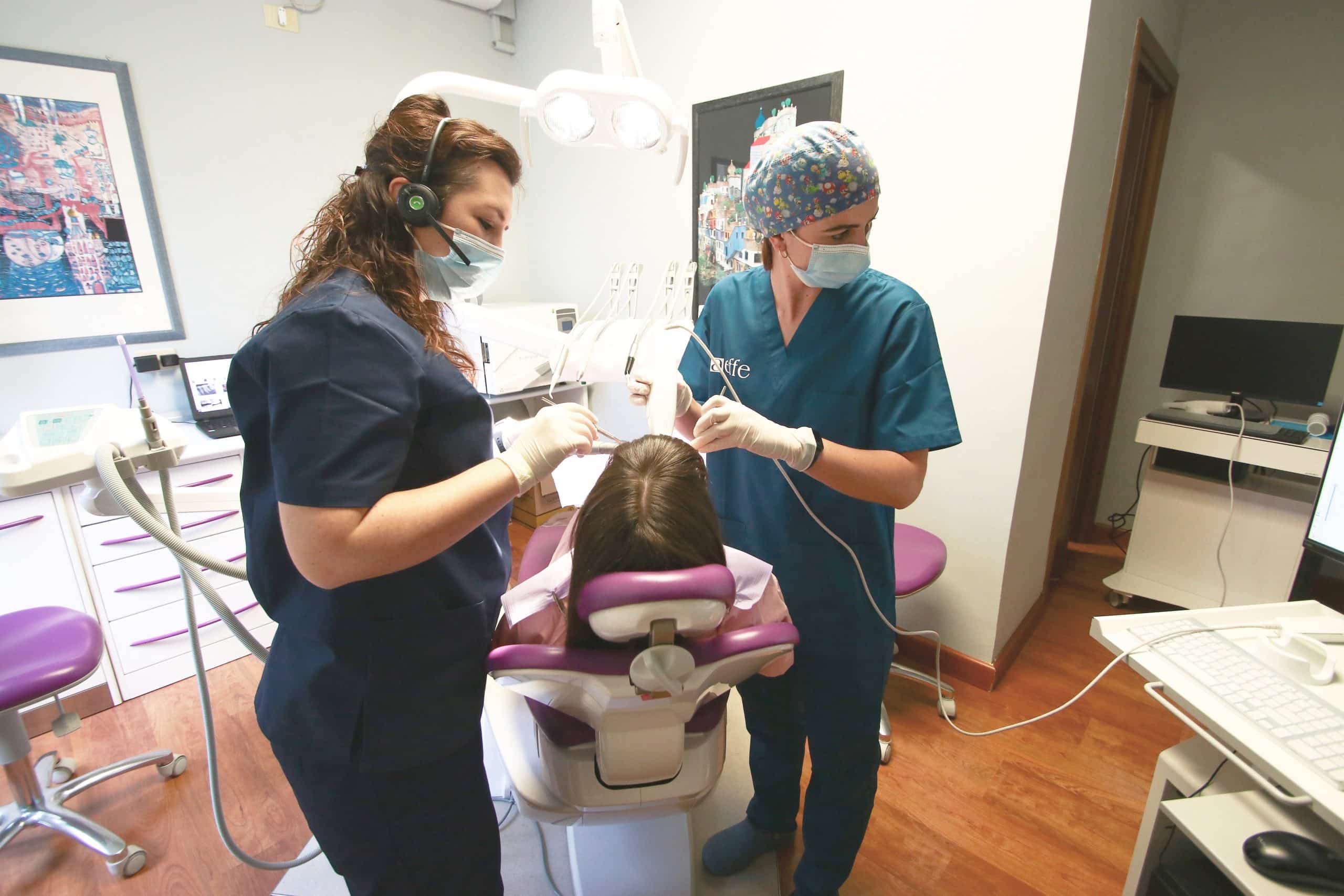 Due dentisti curano un paziente in uno studio dentistico.