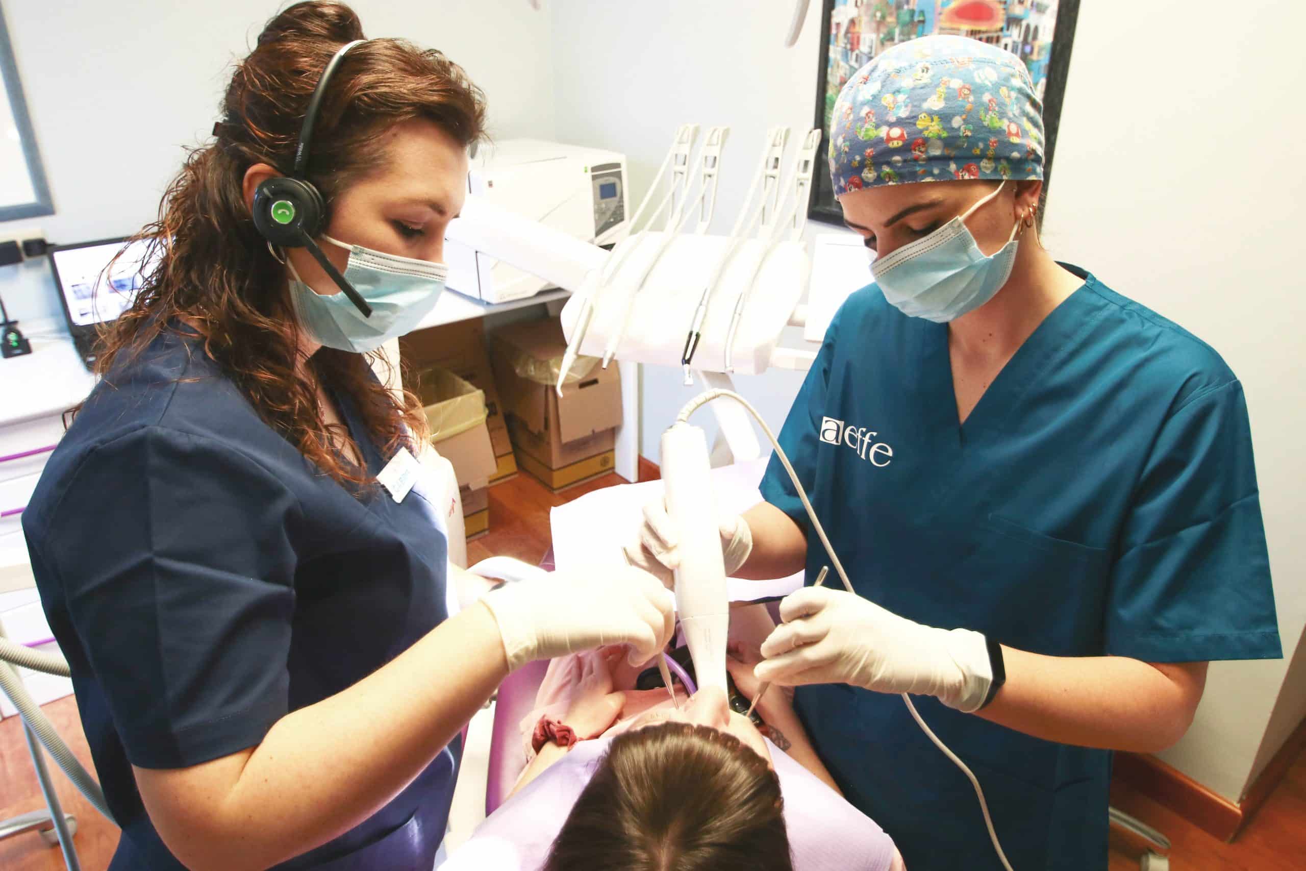 Due dentisti curano un paziente in uno studio.