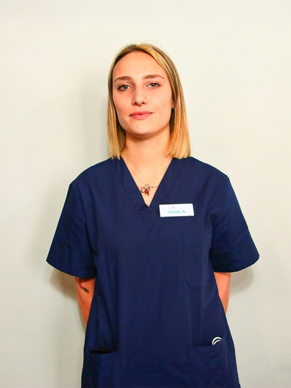Donna in uniforme medica blu con cartellino.