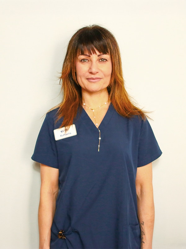 Donna in uniforme medica blu con targhetta.